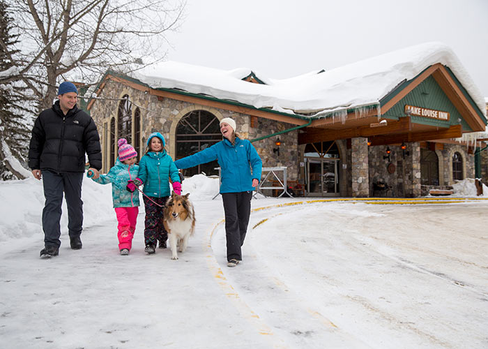 Happy family walking dog at Lake Louise Inn