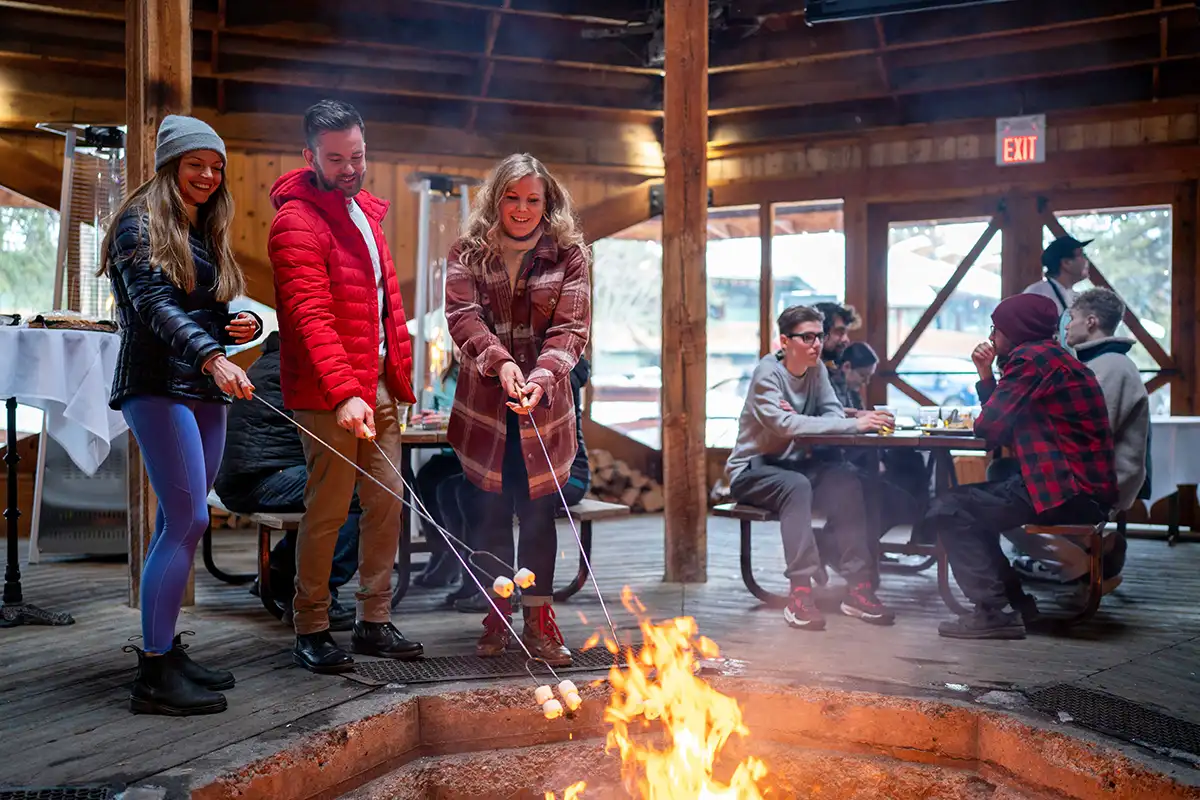 Guests roasting marshmallows at the Gazebo at Lake Louise Inn